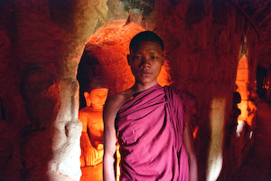 Monk in the Temple with Buddhas by Jim Patton